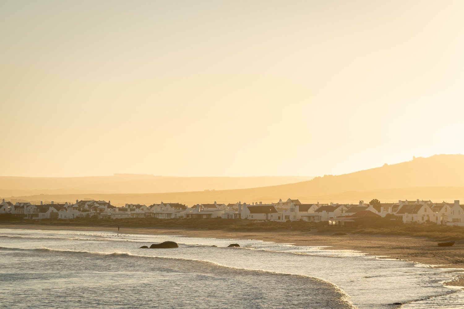 The whitewashed cottages of Paternoster along the beach at sunset